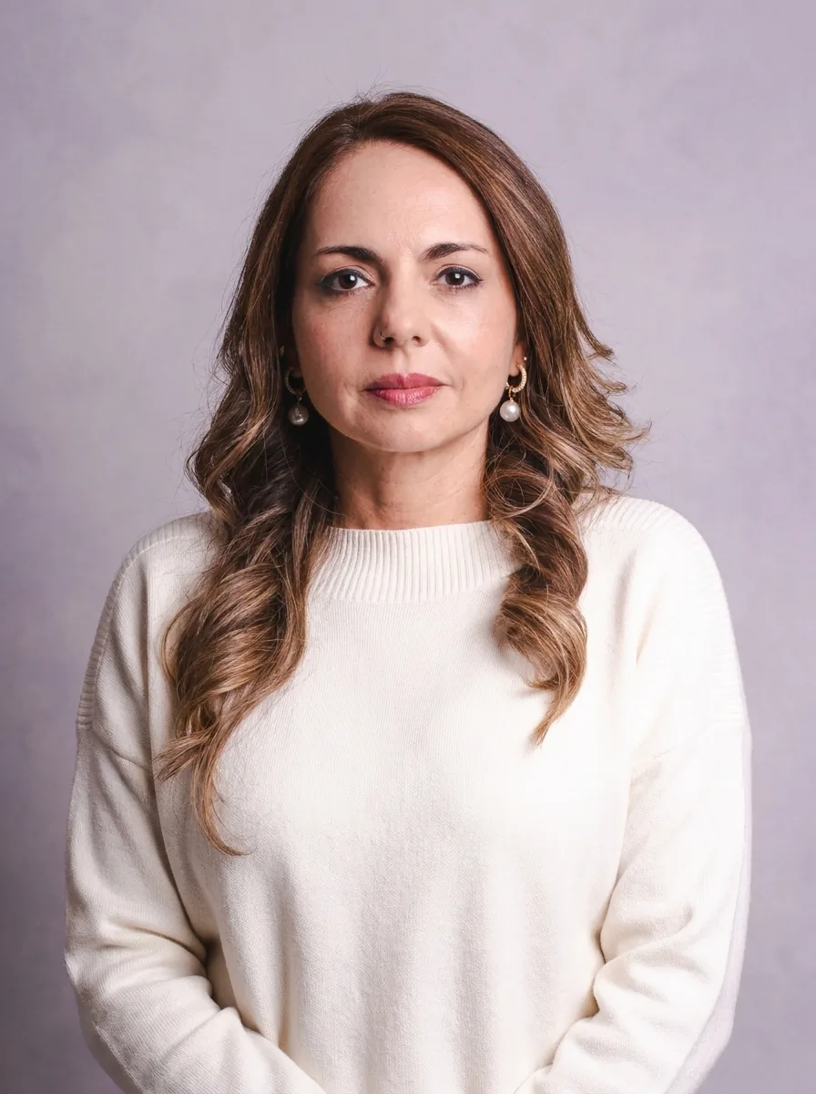 Maggie Pulido en retrato de estudio con suéter crema sobre fondo lila